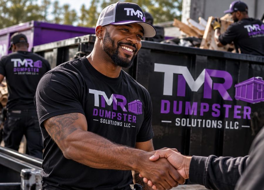 TMR crew member shaking hands with a customer in front of a TMR dumpster